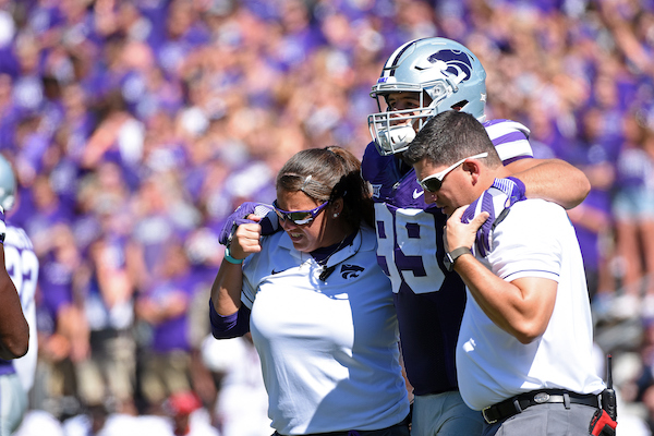 Dissinger Reed K-State | Matt Thomason and Mindy Hoffman help an injured K-State football player off the field